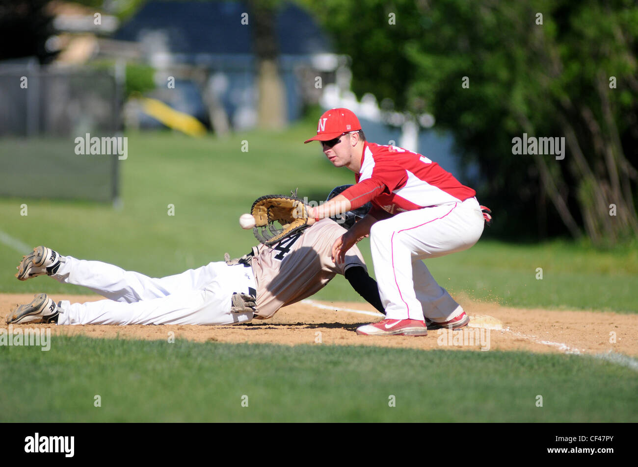 base runner dives back into first base just ahead of the throw on an