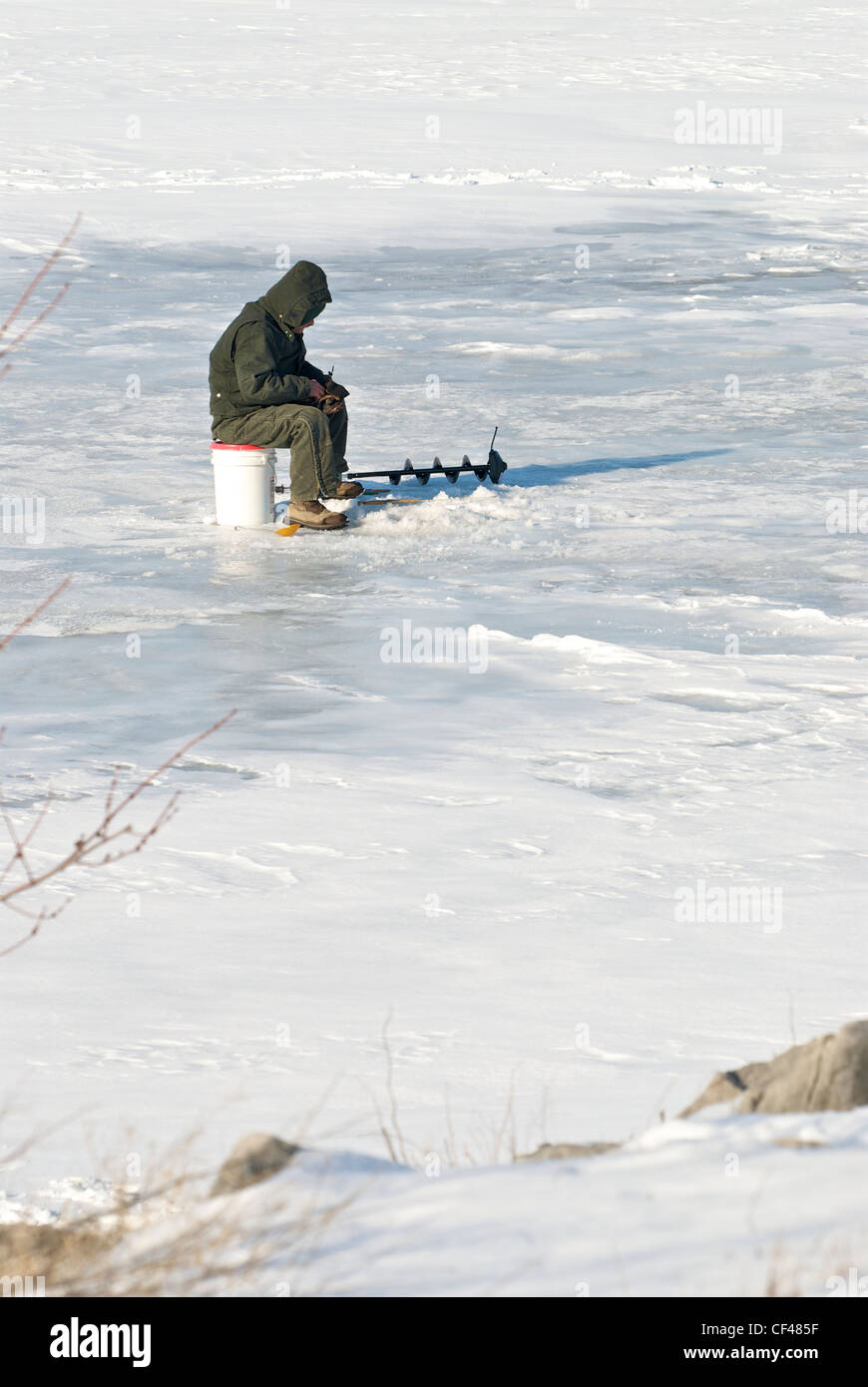 man ice fishing on Lake Erie Stock Photo