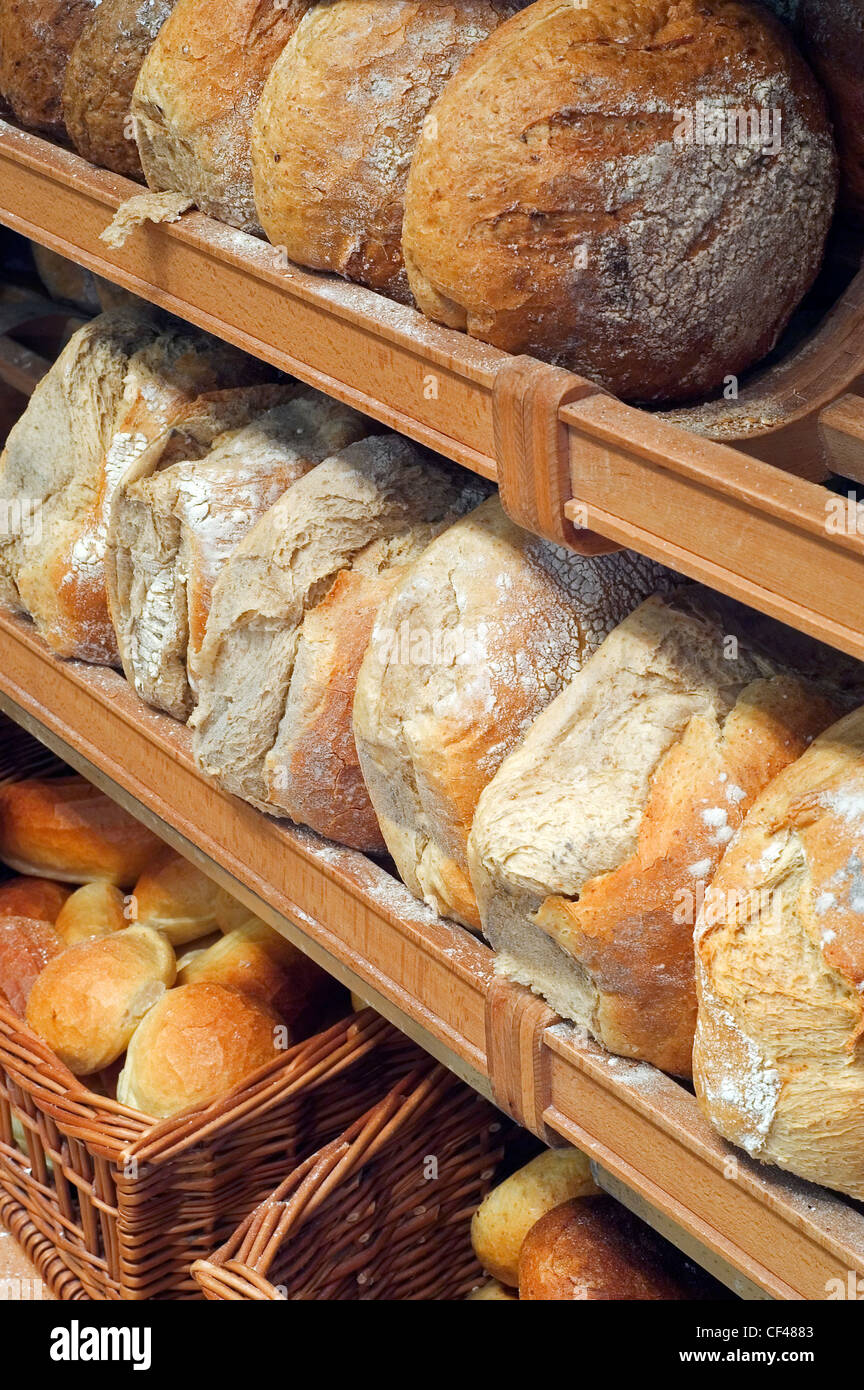 Shelves with loaves of fresh baked bread on display in bakery shop, Belgium Stock Photo