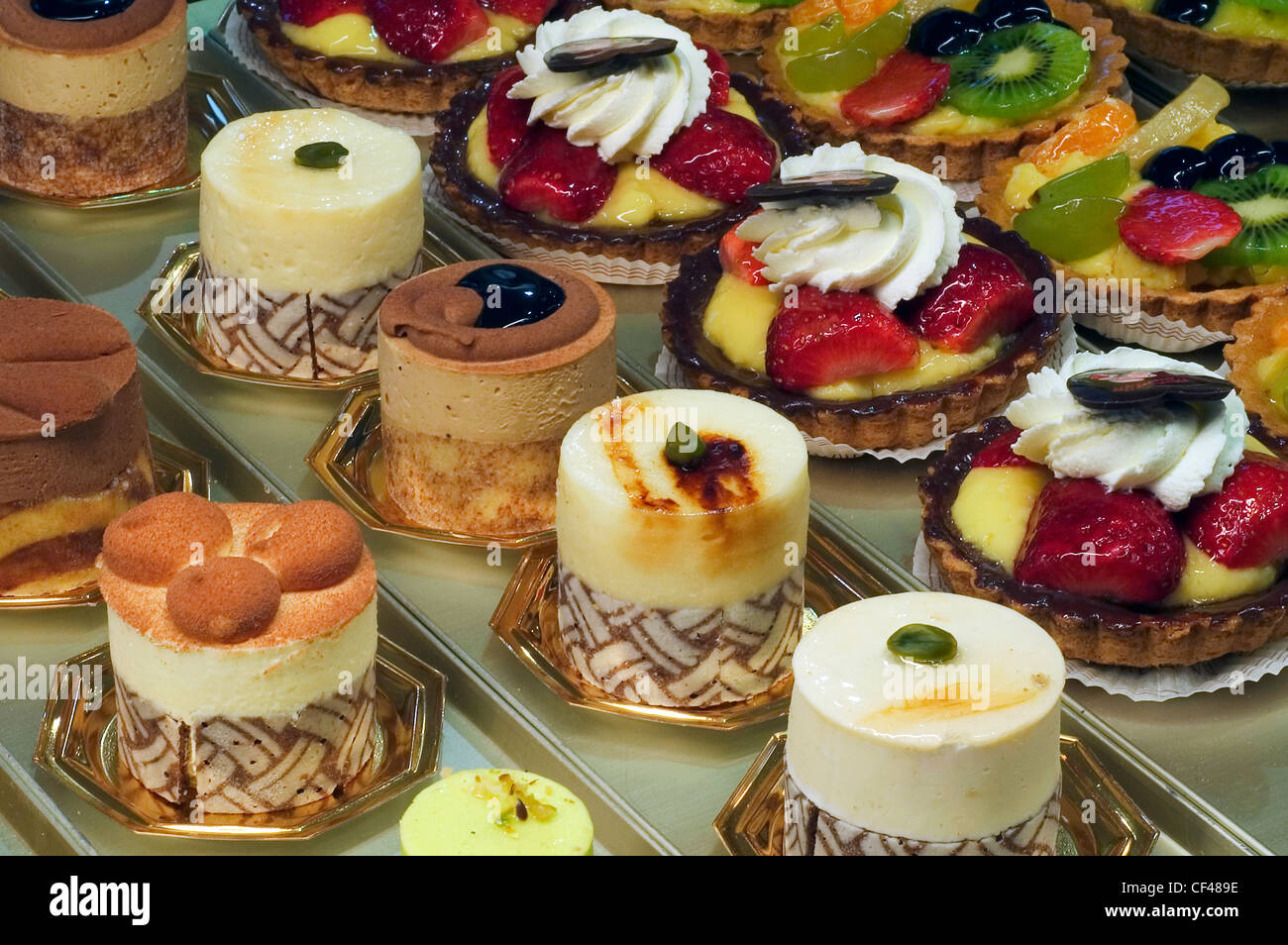 Pastries, cakes and fruit pies on display in pastry shop Stock Photo