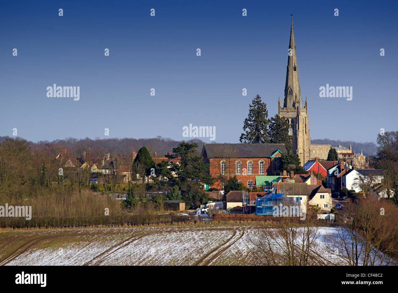 Snow melts on fields in front of the church and buildings of Thaxted in Essex. Stock Photo