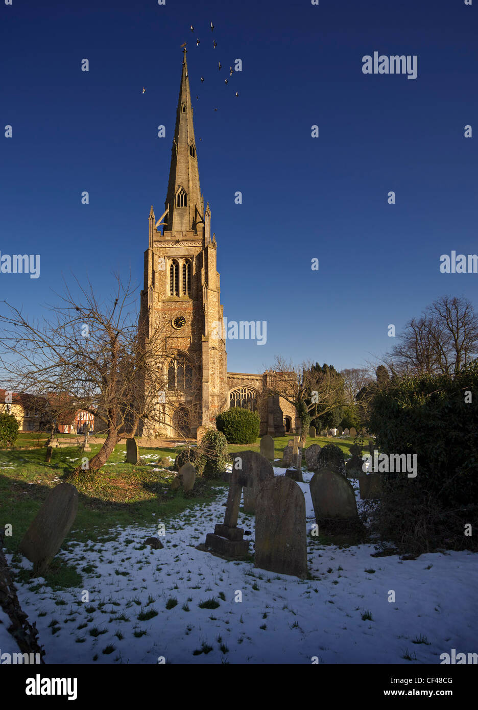 Snow melting on the ground at Thaxted Church graveyard. Stock Photo