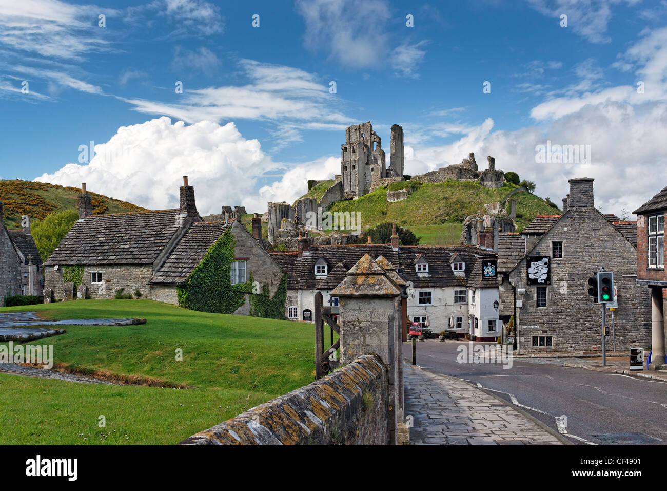 Corfe Castle commanding a gap in the Purbeck Hills overlooking the Bankes Arms Hotel, is now an imposing ruin and a popular tour Stock Photo