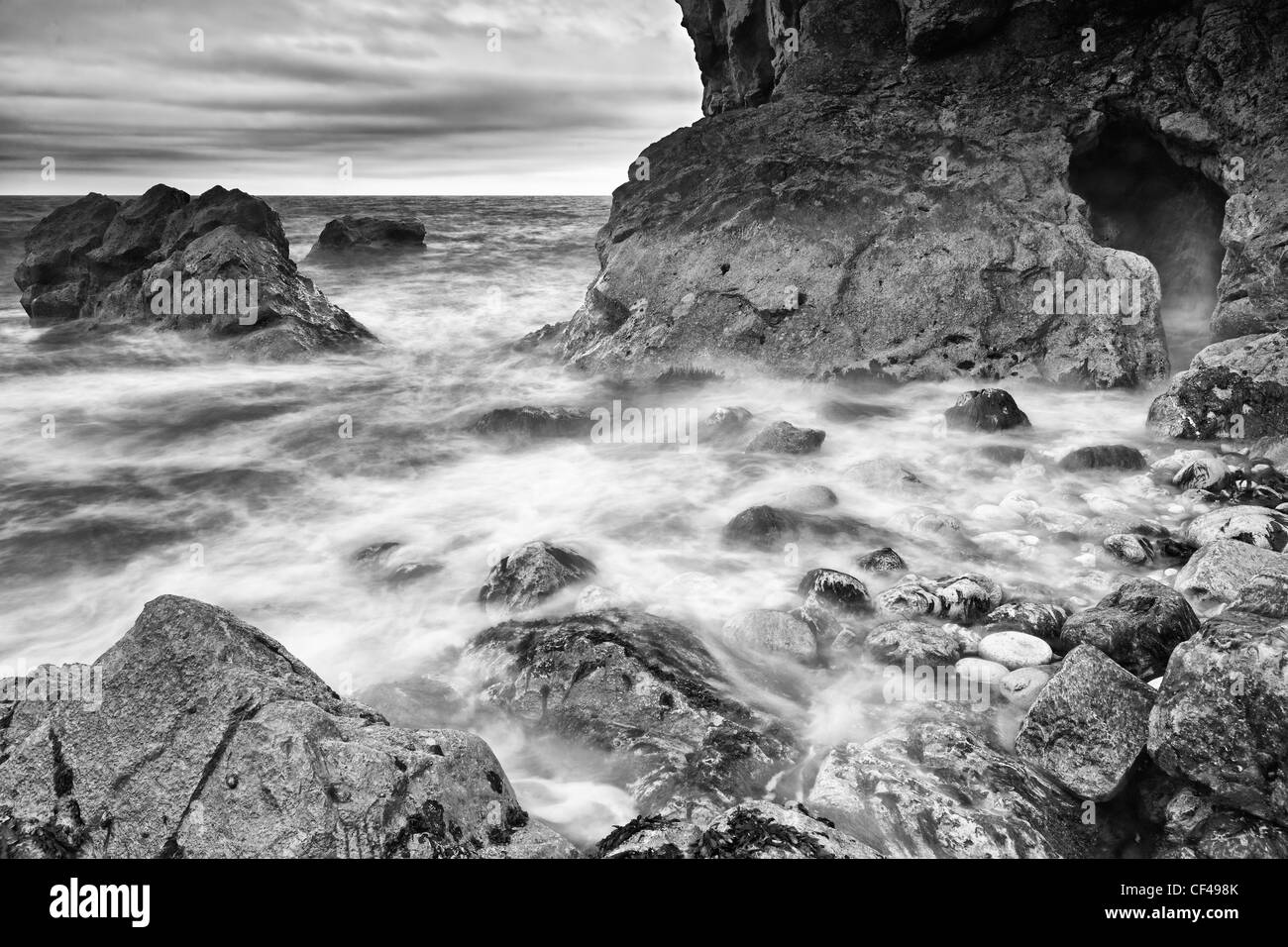 Sea swirling in and around rocks in Stair Hole, a relatively new cove that is forming just to the west of Lulworth Cove in Dorse Stock Photo