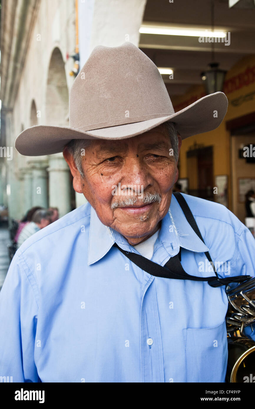 immaculately dressed elderly musician poses for portrait after playing a solo for tourists in restaurant arcade Oaxaca Zocalo Stock Photo