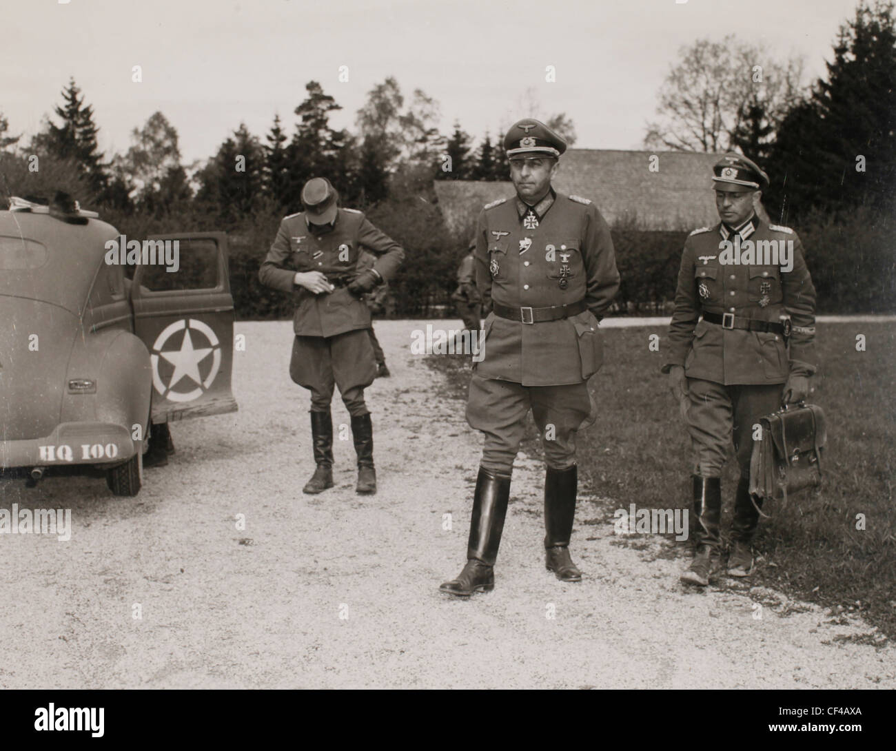 Nazi Generals from German Army Group G stand near a road and a car after their unconditional surrender during the last days of W Stock Photo