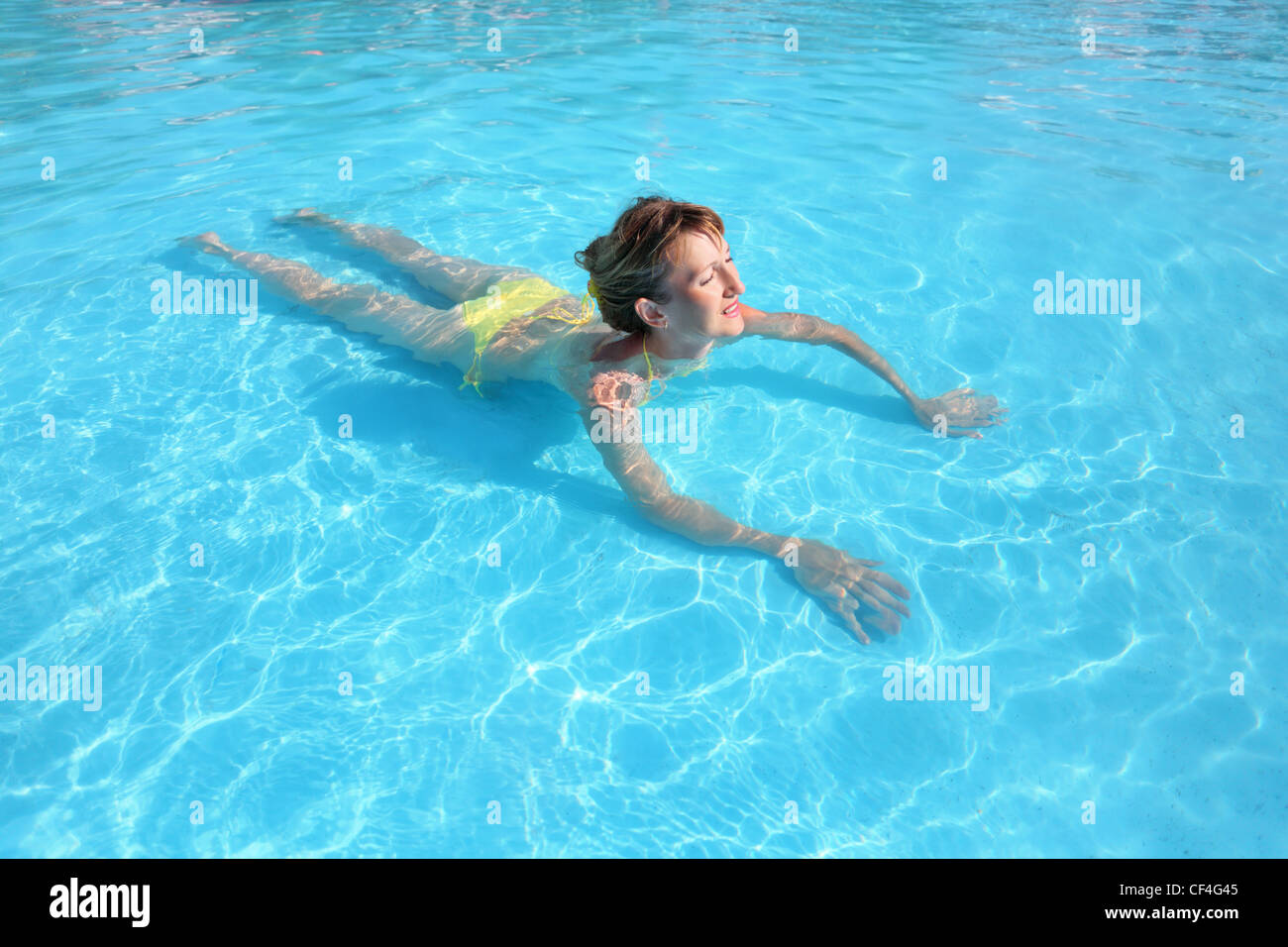 Woman yellow bikini pool hi-res stock 