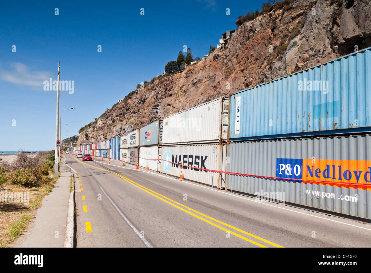 Shipping containers protect traffic from rockfalls at Sumner, Christchurch, New Zealand. Stock Photo