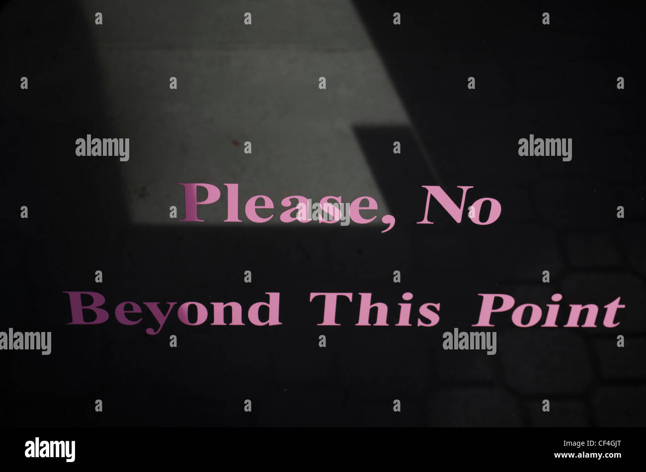 'Please, No Beyond this point' Written in pink on a glass door. Stock Photo