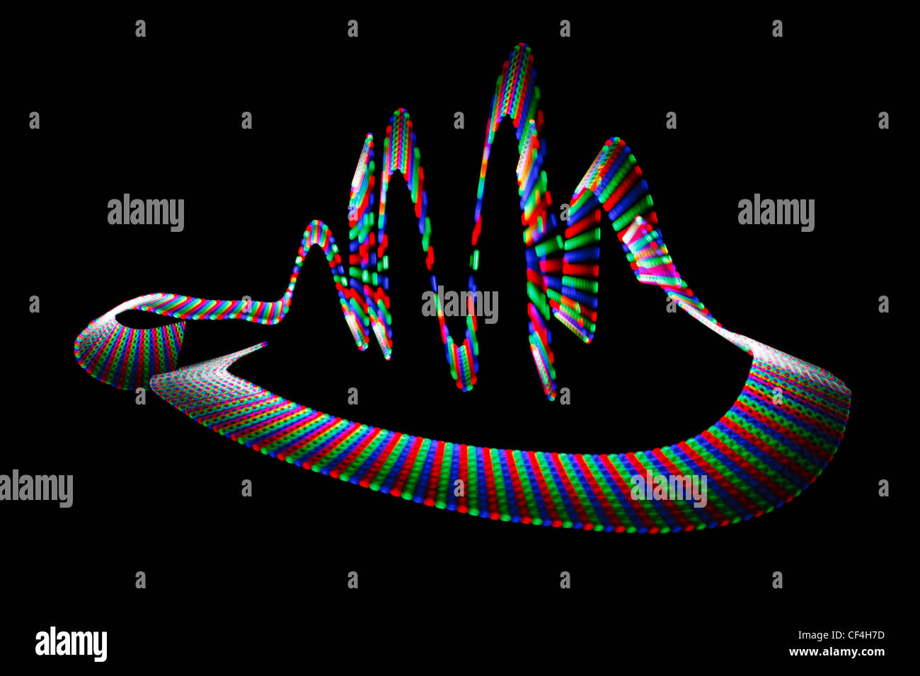 Multi-coloured wavy trace of light-emitting diode on black background. Stock Photo