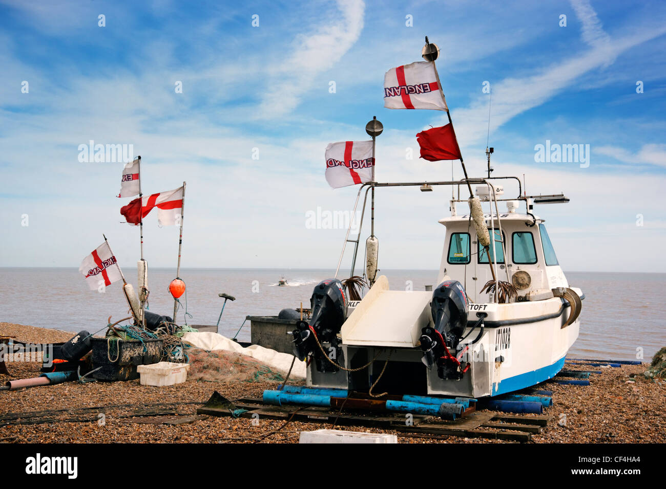 England flags flying from a fishing boat and equipment on the beach at Aldeburgh. Stock Photo