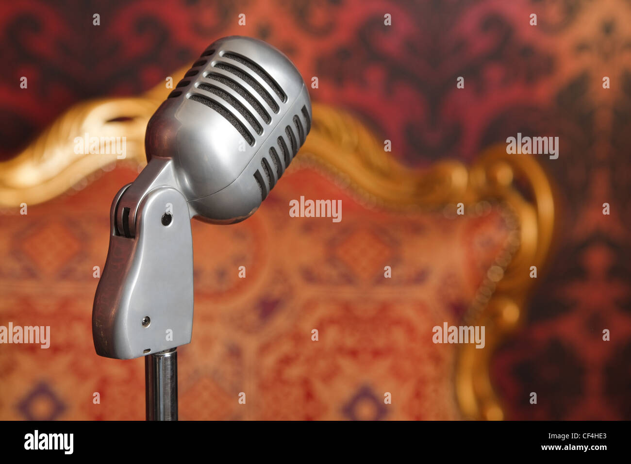vintage metal microphone on a stand photographed against a background