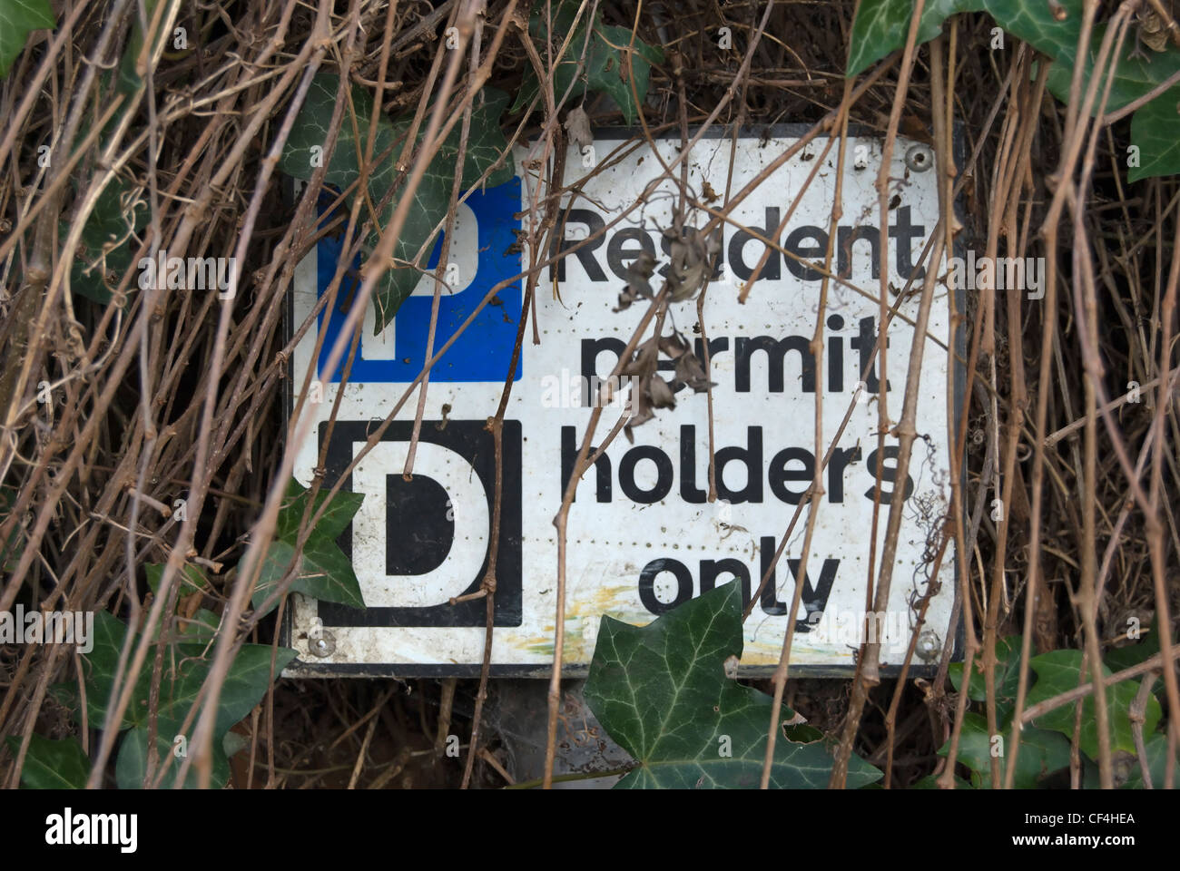 Resident Permit Holders Only Parking Sign Partly Obscured By Vegetation