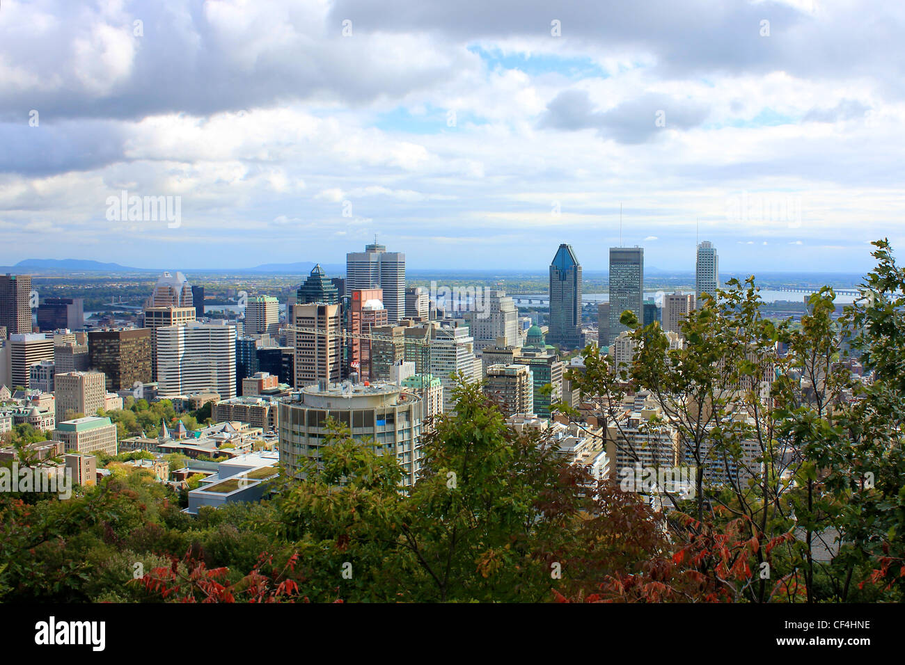 A view of Montreal, Quebec past the trees on the hill at Parc du Mont-Royal. Stock Photo