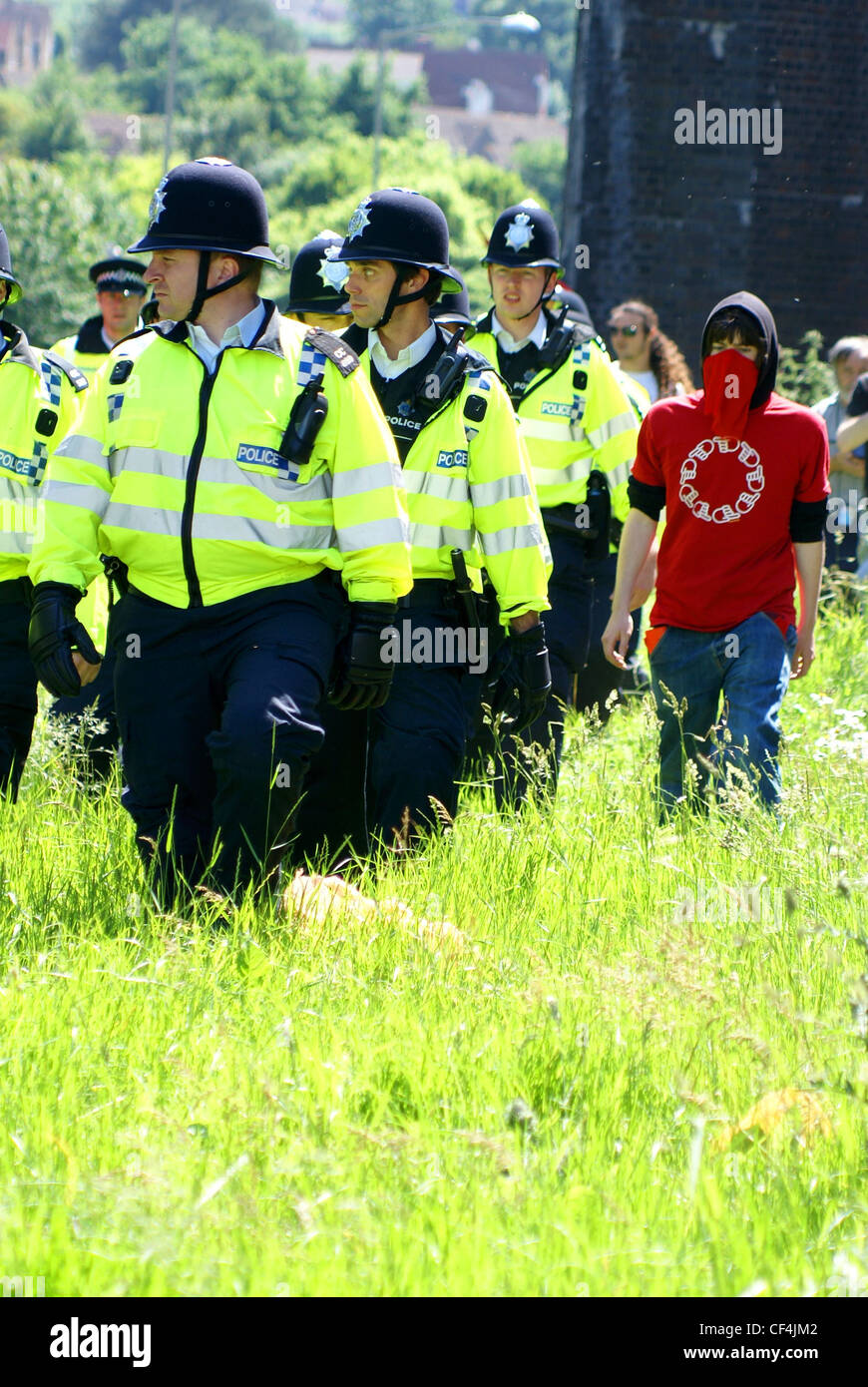 A lone protester walks alongside a line of police officers. Stock Photo