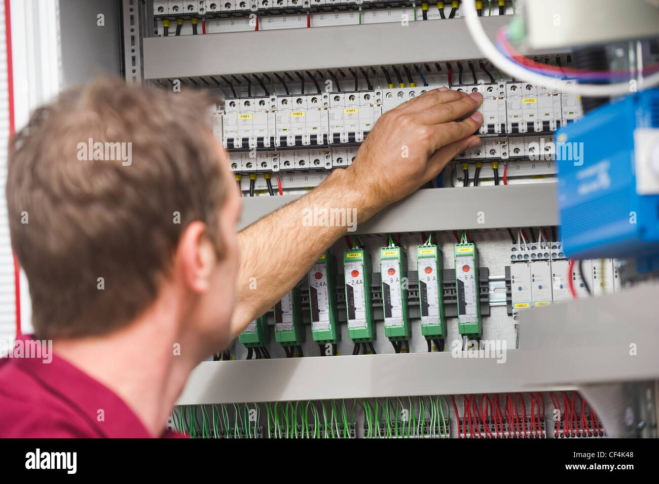 Germany, Munich, Technician checking switch button of circuit board Stock Photo