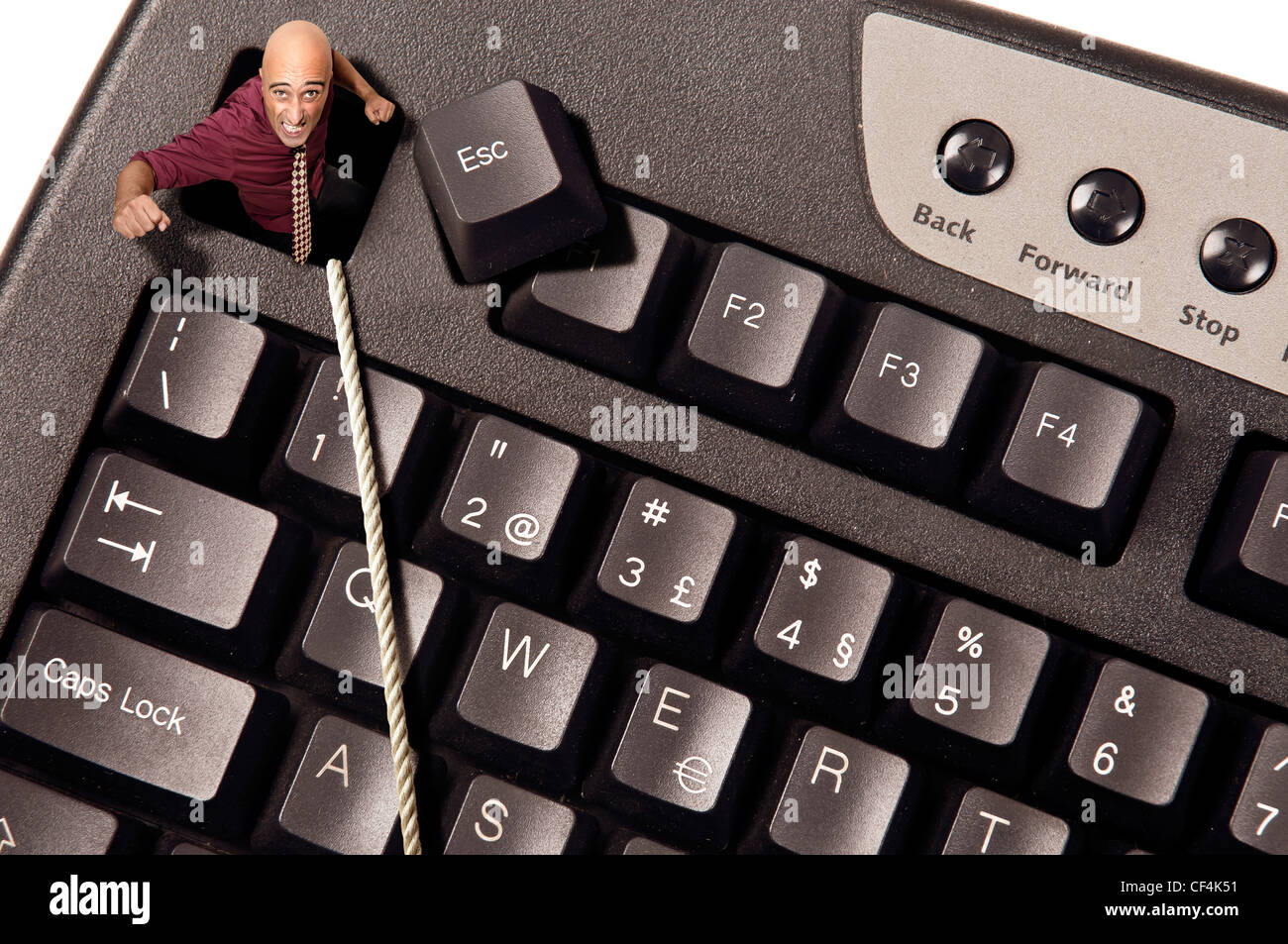Businessman escaping from Escape key in a computer keyboard Stock Photo