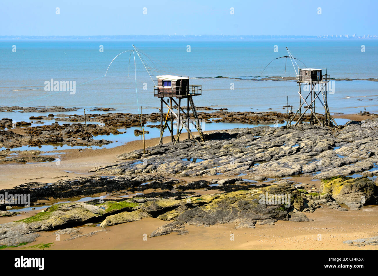 Fishing carrelets from Saint Michel Chef Chef at low tide and the town of Saint Nazaire in the background Stock Photo