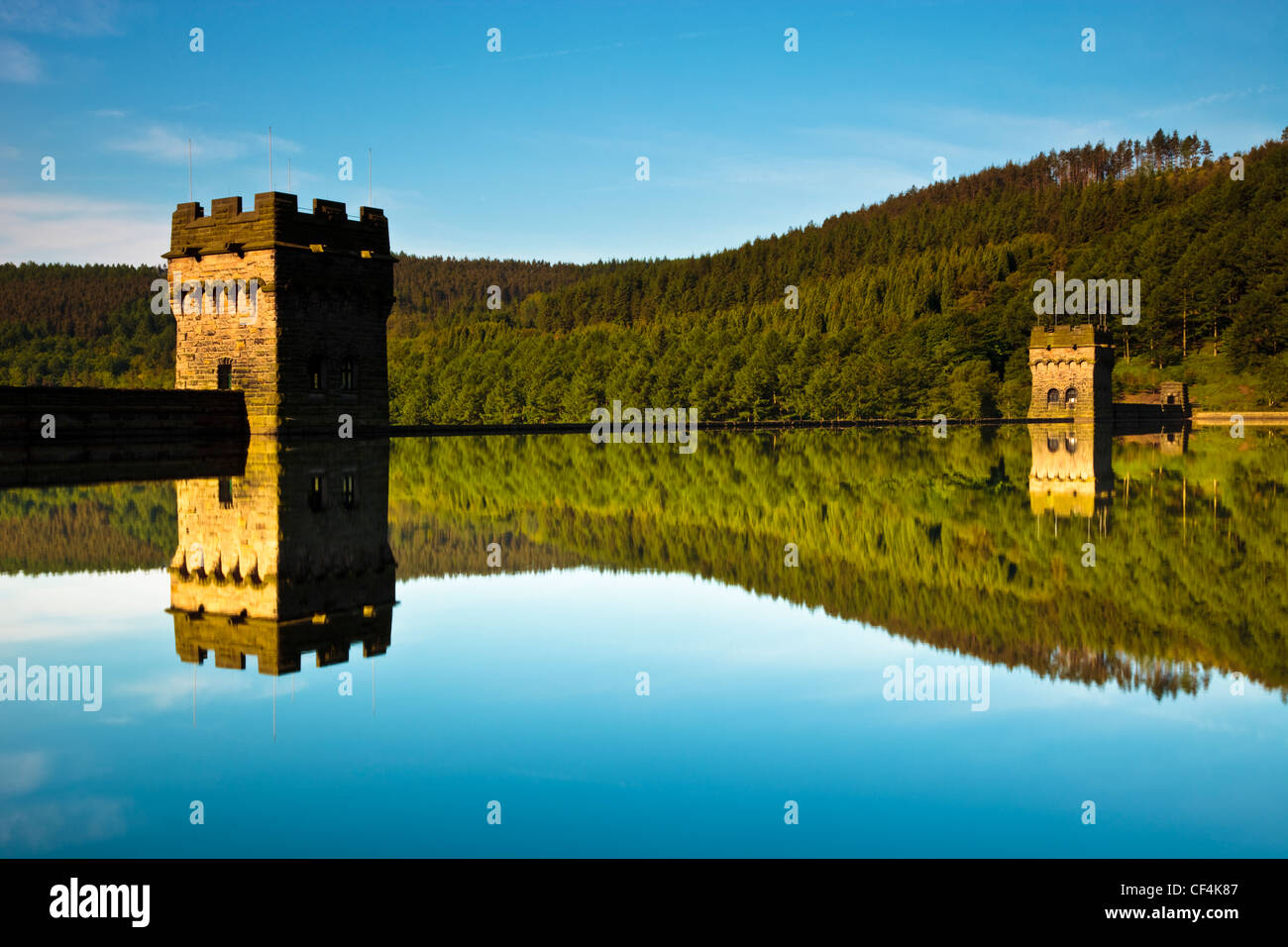 Reflection of Derwent Dam in the calm waters of the Derwent reservoir on a spring morning. The Derwent reservoir was used by the Stock Photo