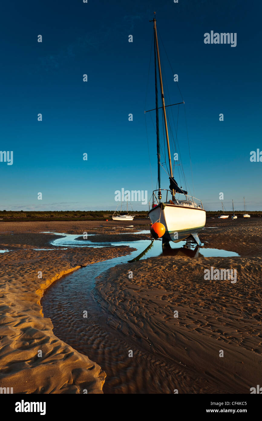 Boats on the sand bank at low tide at Wells-Next-the-Sea on the Norfolk Coast. Stock Photo