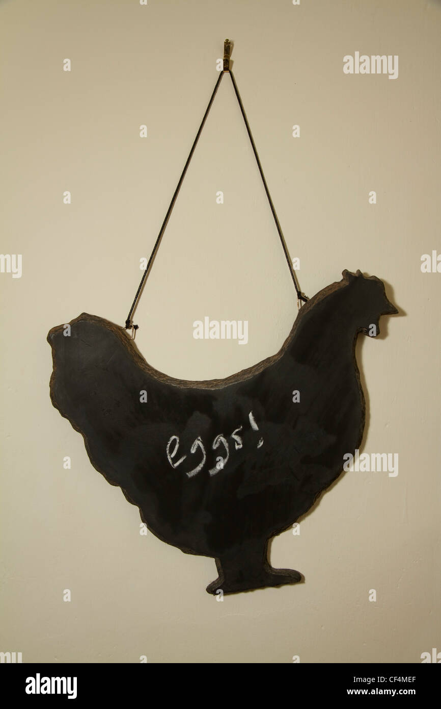 A chicken shaped blackboard hangs on a kitchen wall for reminder/shopping lists Stock Photo