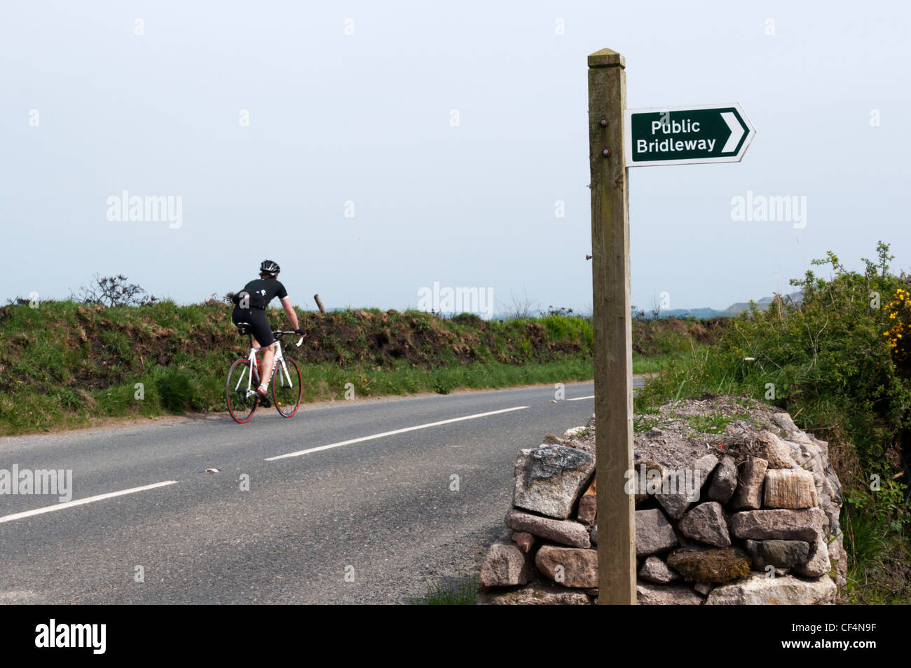 A cyclist passing a Public Bridleway sign in North Cornwall, England. Stock Photo