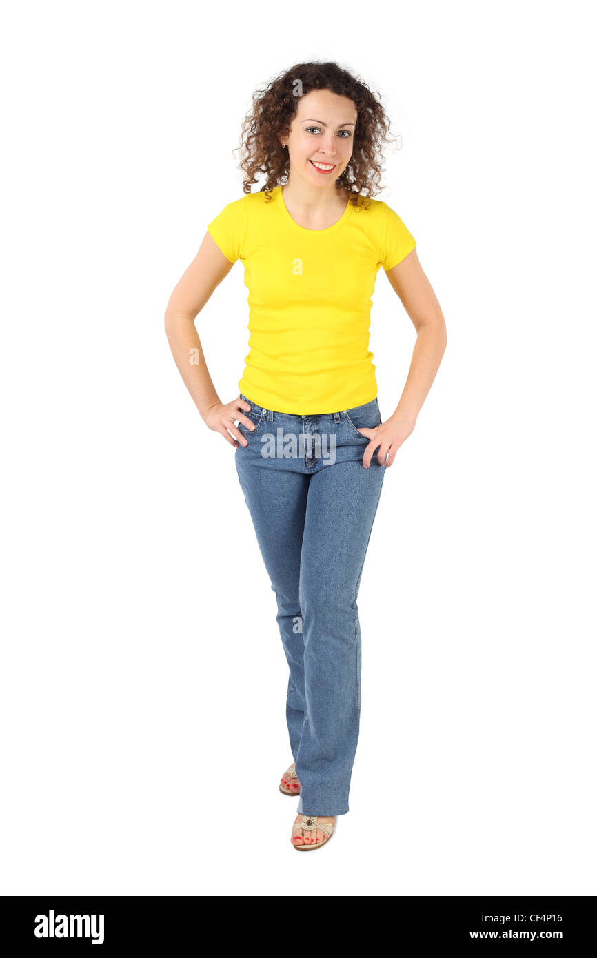 young attractive woman in yellow shirt and jeans standing, hands on ...