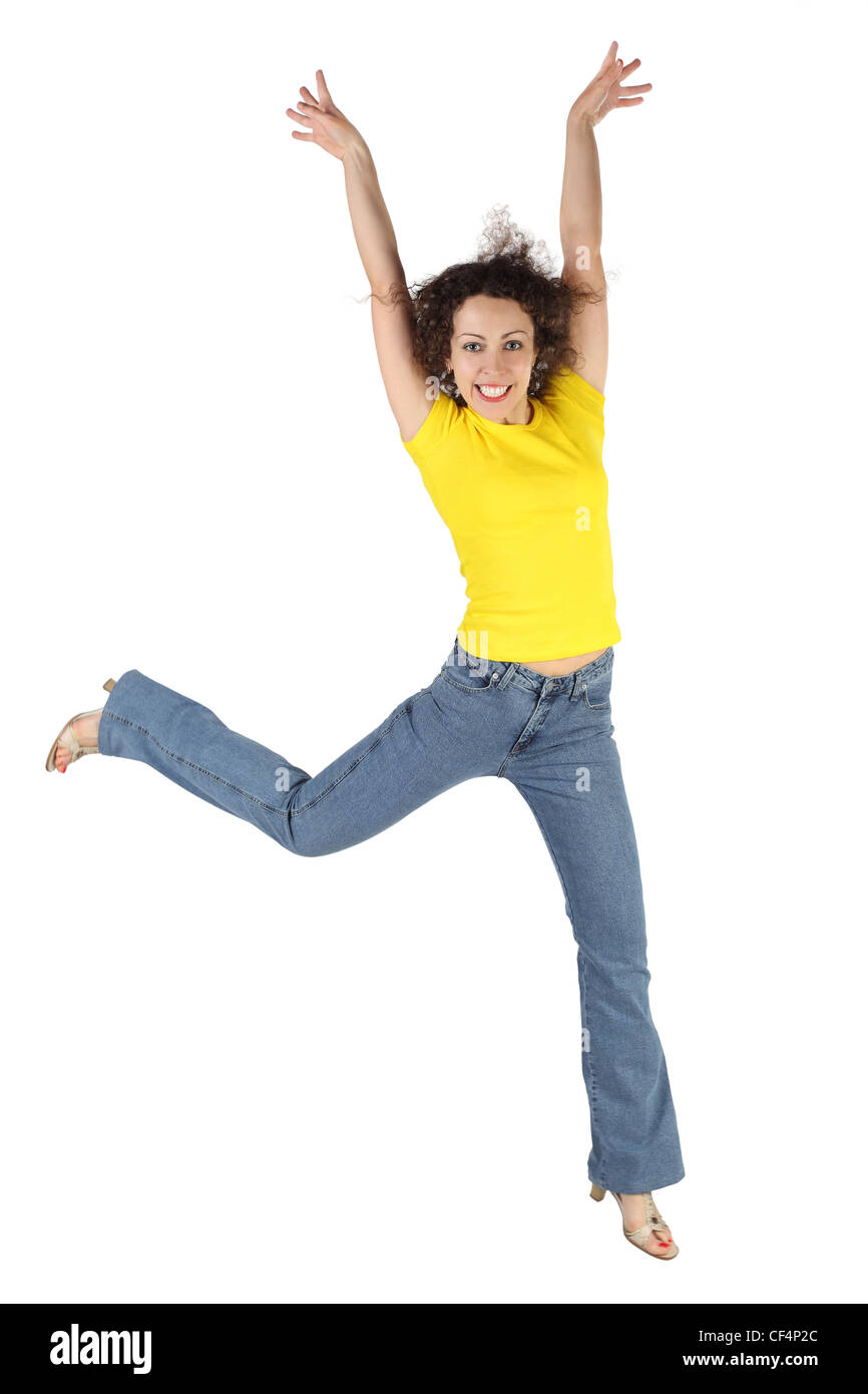 young attractive woman in yellow shirt and jeans jumping and smiling ...