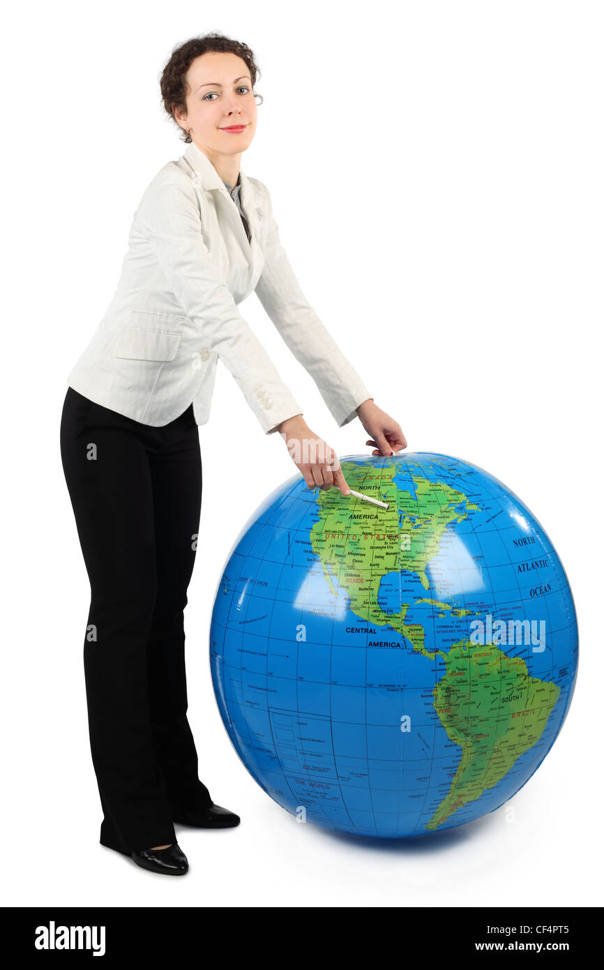 young woman in white jacket standing and pointing at North America on big inflatable globe, isolated on white Stock Photo