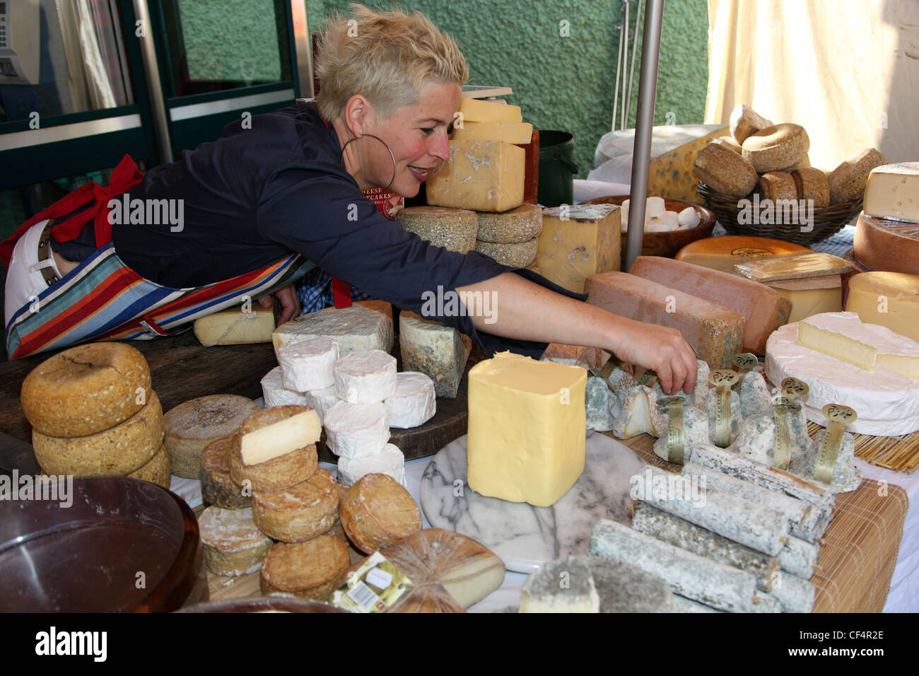 Maja Binder, an artisan cheesemaker, arranging her handmade organic cheeses on her stall at Dingle Market. Stock Photo