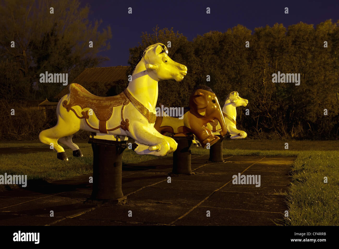Animal themed Sit-In Spring Mobiles in a childrens playground at night. Stock Photo