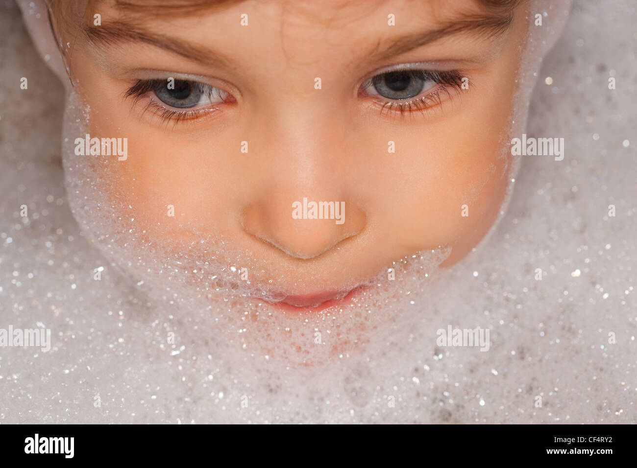 Small Child Taking A Bath, The Head Of Foam. Looks Toward Stock Photo 