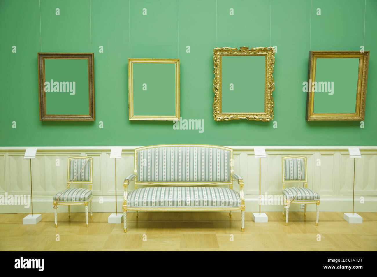 picture frames in green room of museum, stripes chair and sofa with golden wood Stock Photo