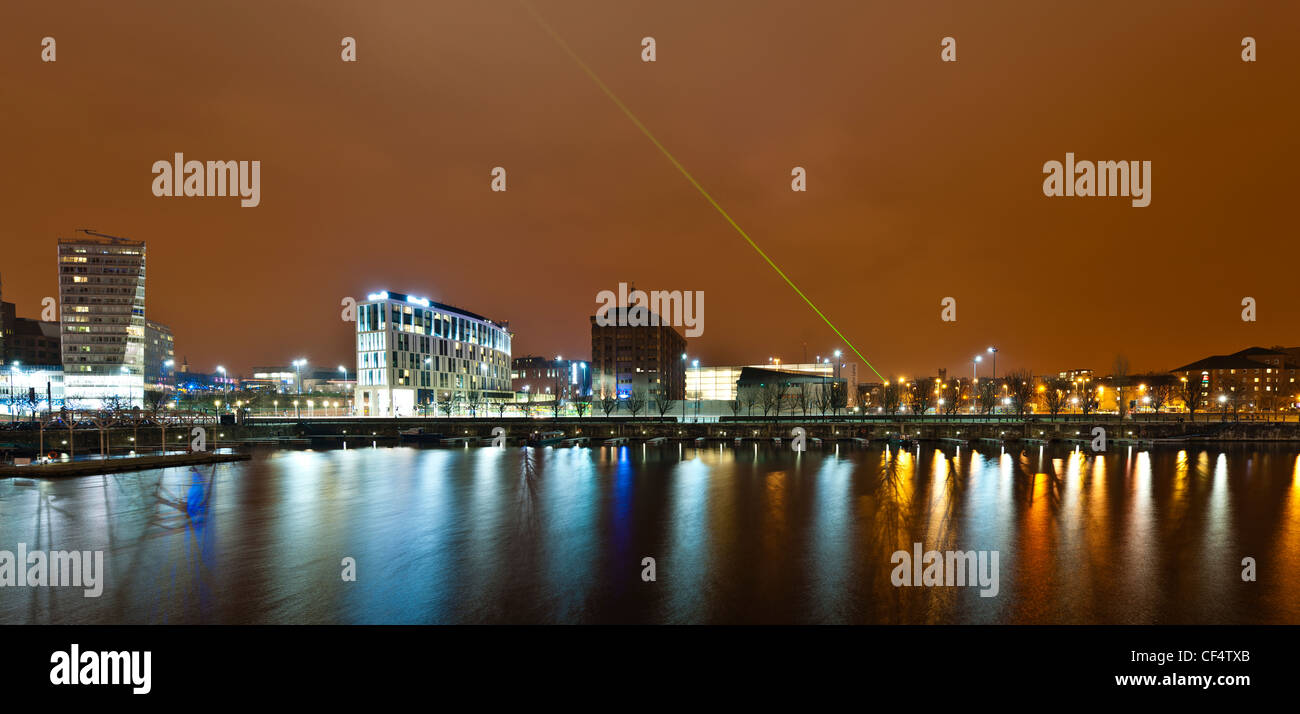 Liverpool One shopping centre with green laser in the night sky and reflections in the waters of Salthouse Dock. Stock Photo