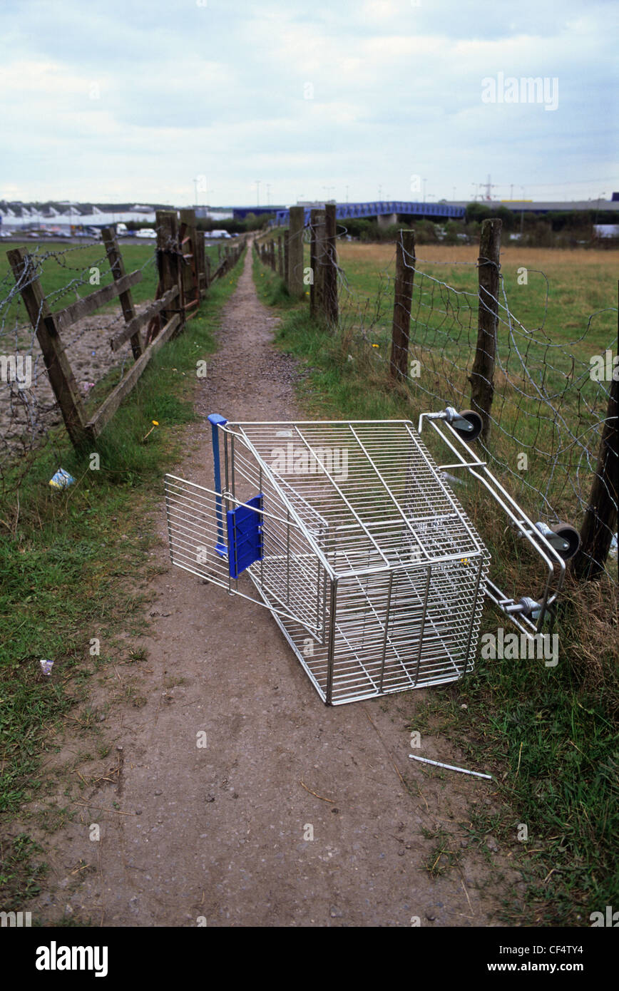 shopping trolley dumped on footpath near shopping outlet Leeds Yorkshire UK Stock Photo