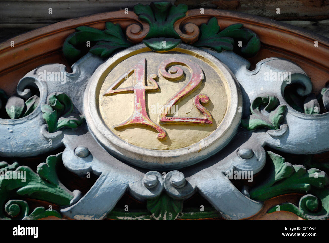 Close up of a decorative building number, 42, above the entrance to a Victorian building. Stock Photo