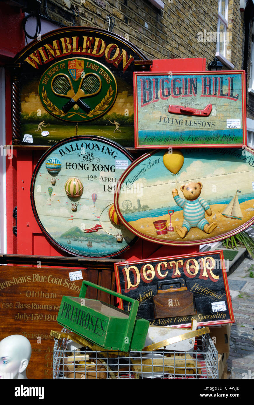 Lots of old hand painted wooden advertising signs for sale outside an antiques shop in Portobello Road. Stock Photo