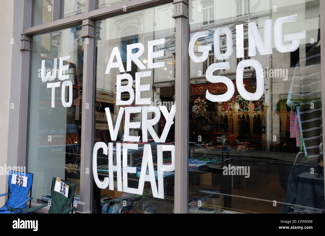'We are going to be so very cheap' written on a clothes shop window in the City of London. Stock Photo