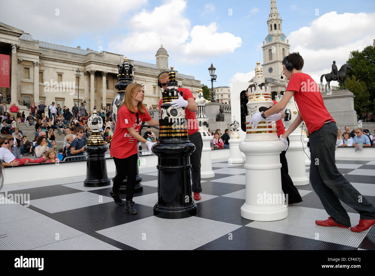 Helpers moving giant chess pieces handcrafted by Jaime Hay√≥n during a game as part of The Tournament, an installation consistin Stock Photo