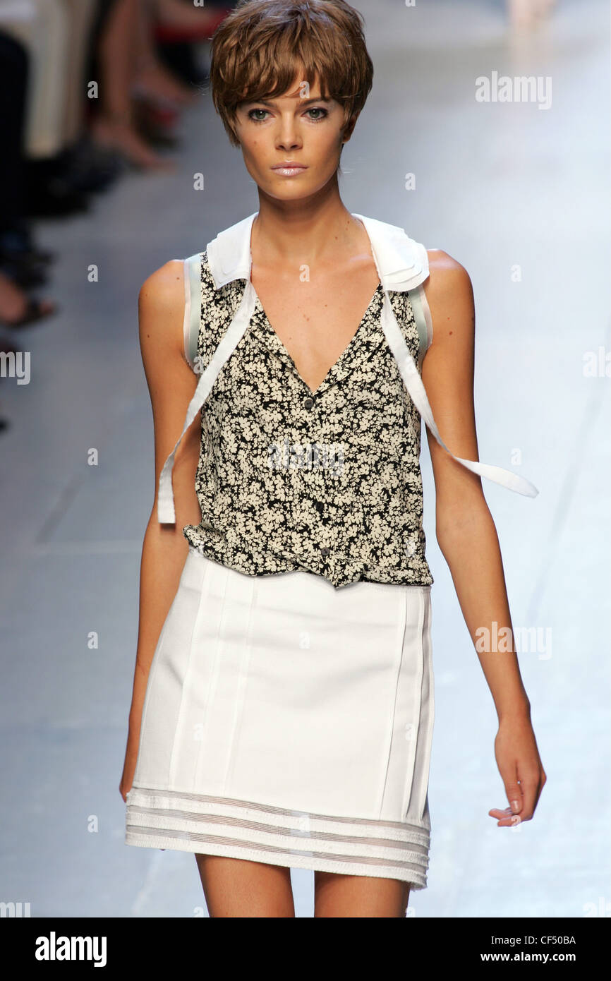 Philosophy Milan Ready to Wear S S Model with cropped hair wearing sleeveless patterned blouse and short white skirt Stock Photo