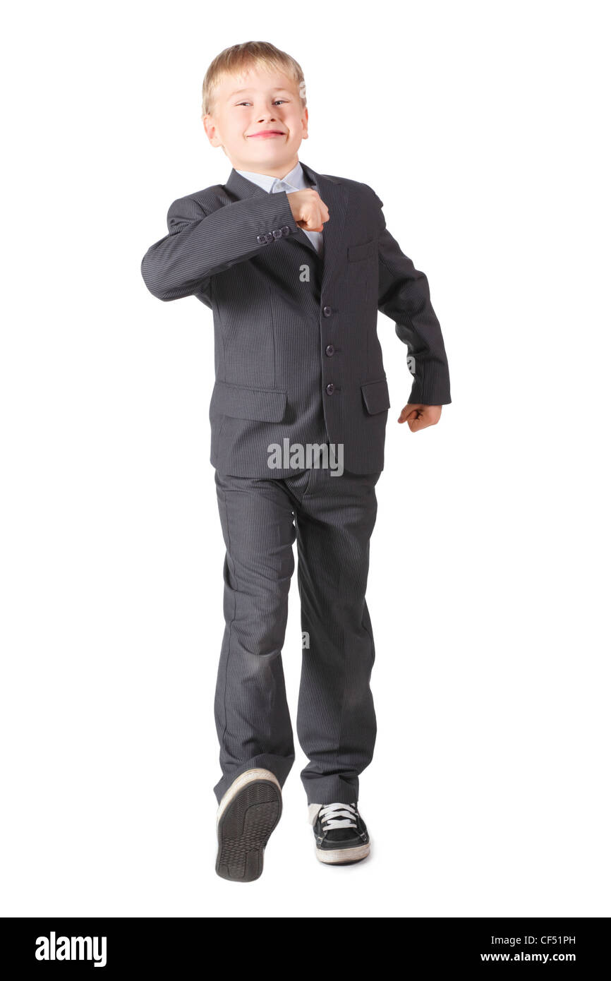joyful schoolboy wearing accurate suit is walking. isolated. Stock Photo