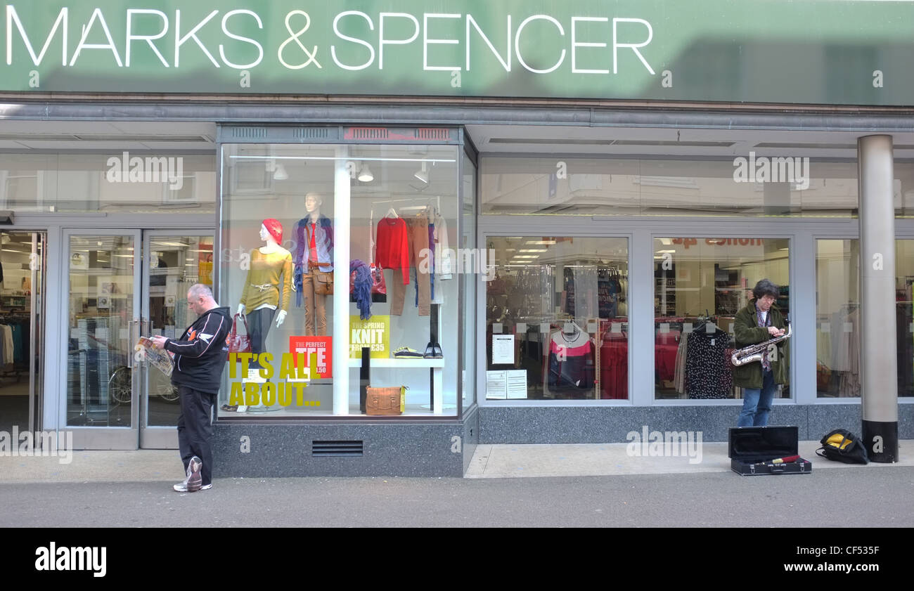 A man and a busker outside Marks & Spencer in Falmouth, Cornwall, UK Stock Photo