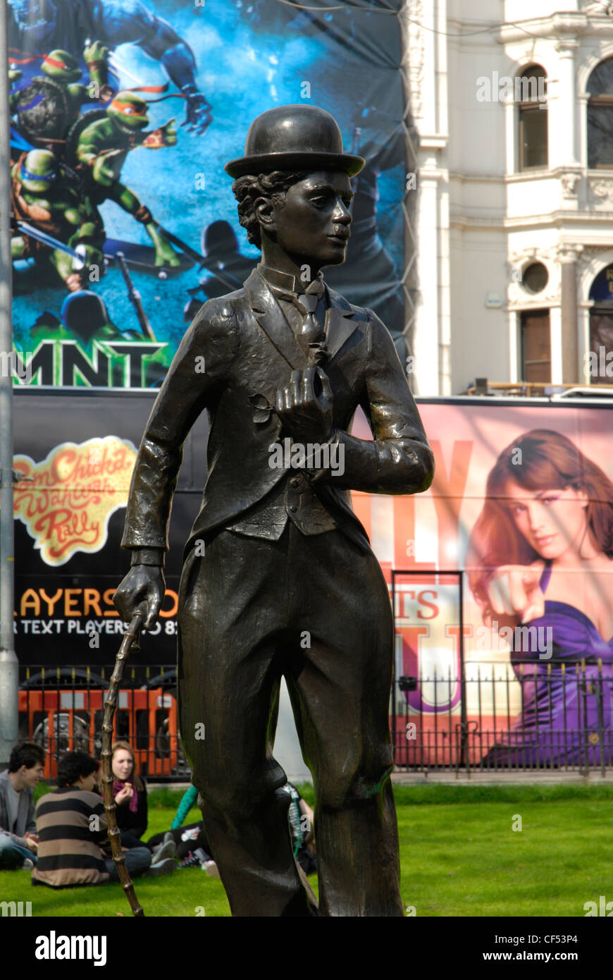 Statue of Charlie Chaplin against background of colourful cinema posters in Leicester Square. Stock Photo
