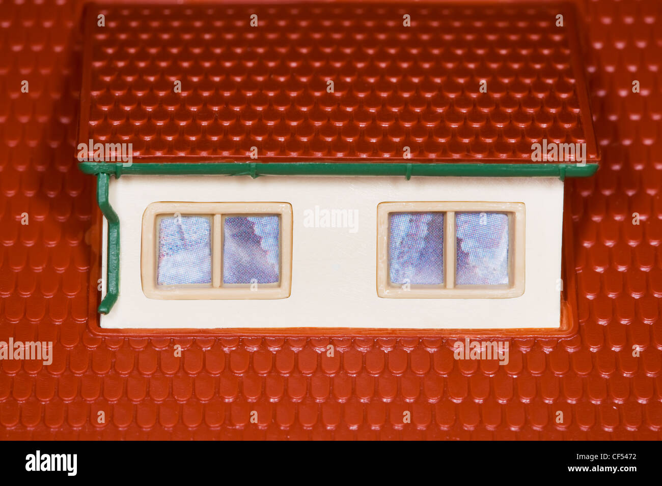 attic on roof of toy plastic house,two windows Stock Photo