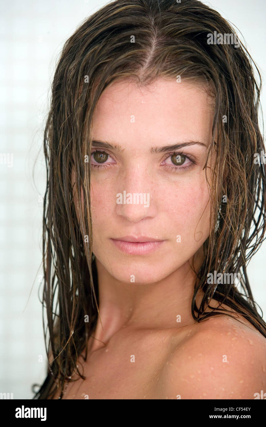 Female with long wet brunette hair turned to look to camera unsmiling Stock Photo