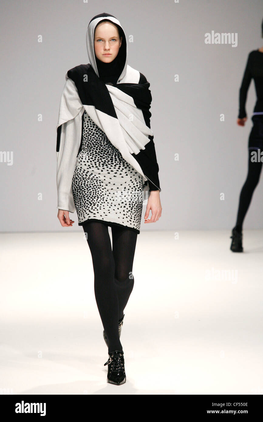 Fashion East London Ready to Wear Autumn Winter Model wearing black and white hooded cape white and black minidress and black Stock Photo