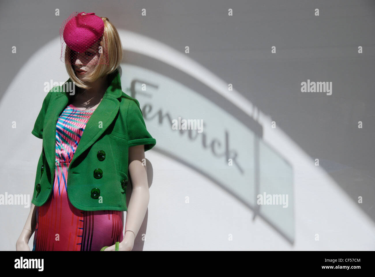 A mannequin in a pink and green outfit on display in Fenwick department store window. Stock Photo