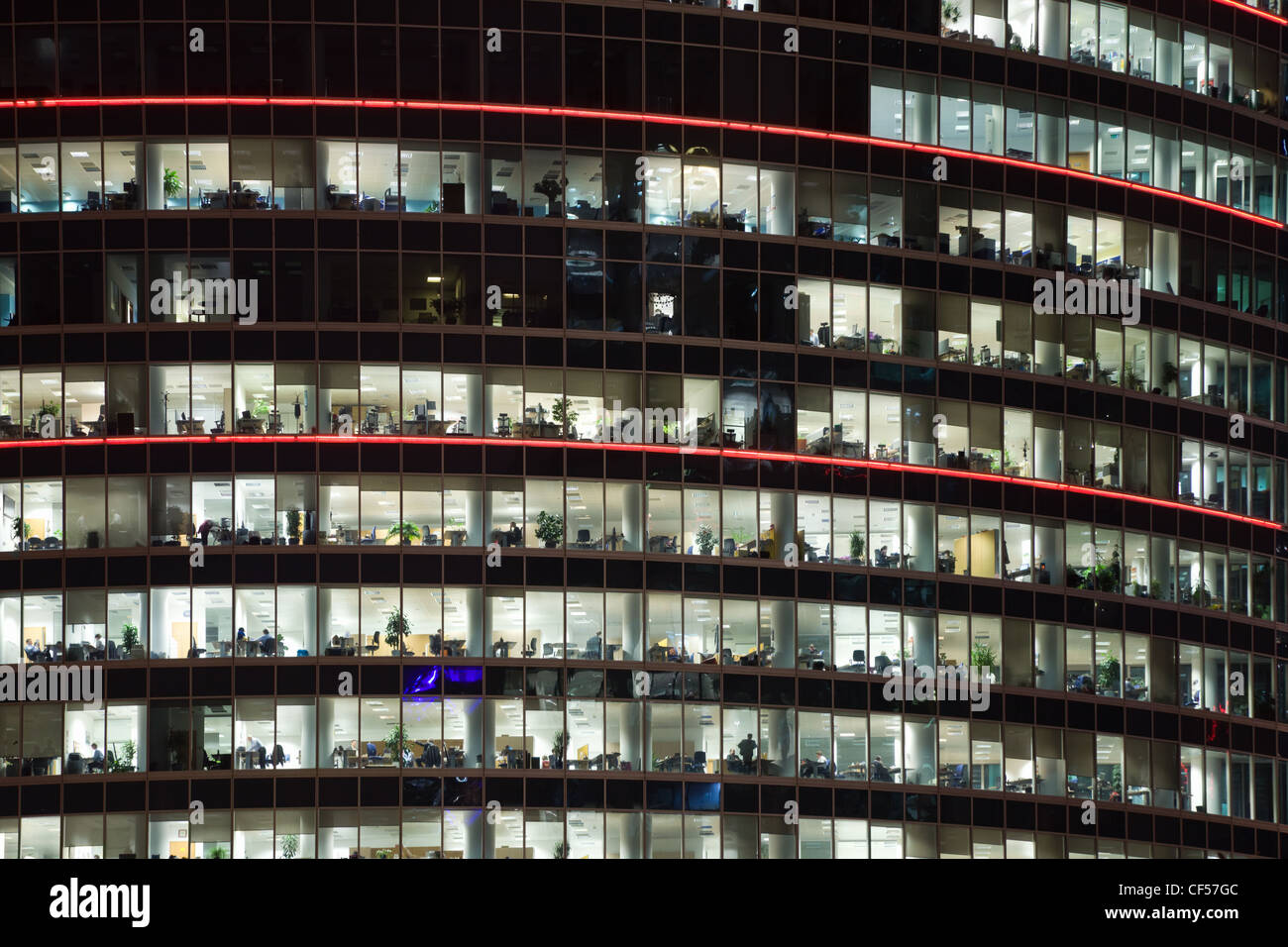 modern office building with big windows at night, in windows light shines Stock Photo