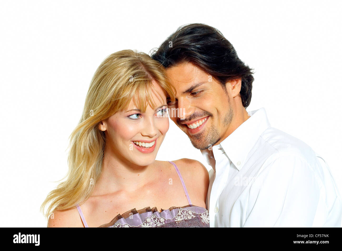 Female long blonde hair wearing lilac sleeveless top standing against male dark hair wearing white shirt looking at her, Stock Photo