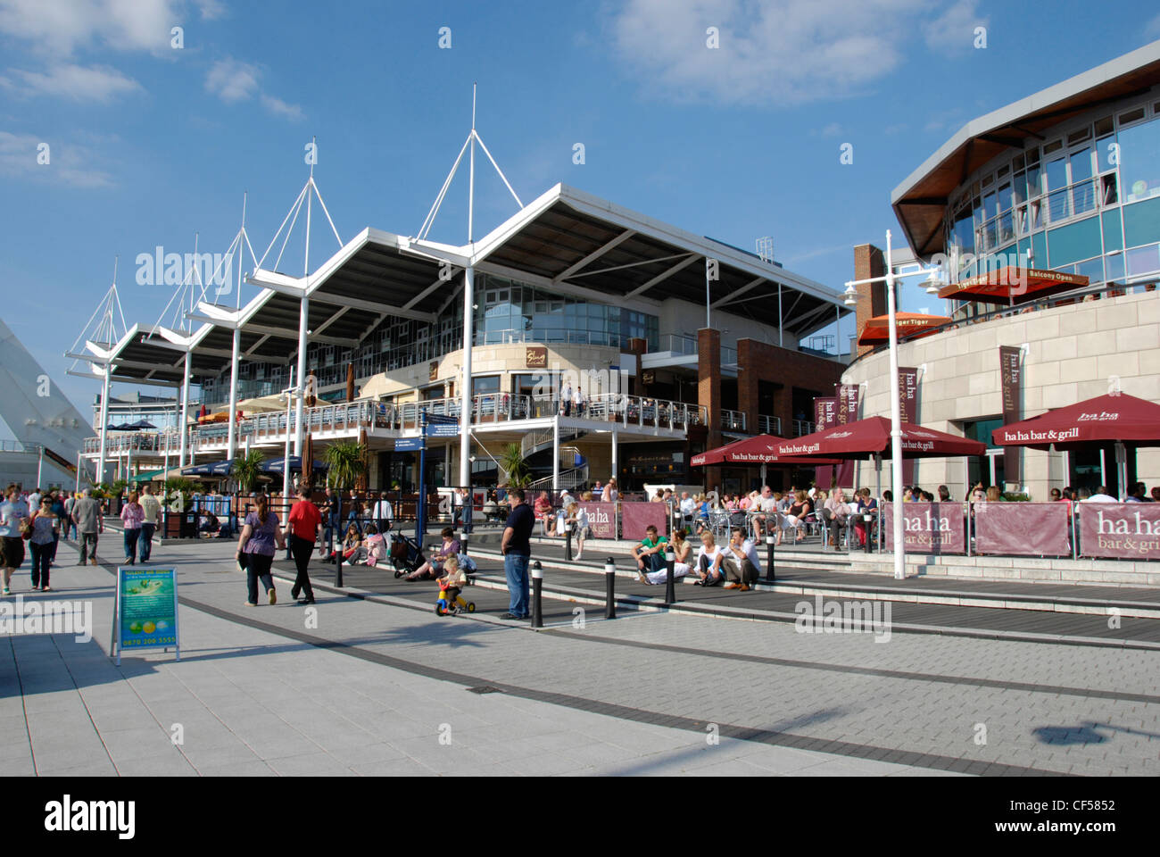 People passing by shops and cafes at Gunwharf Quays in Portsmouth. Stock Photo